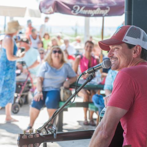 A performer smiles to a crowd at the Mucky Duck, a beachfront restaurant on Captiva Island.