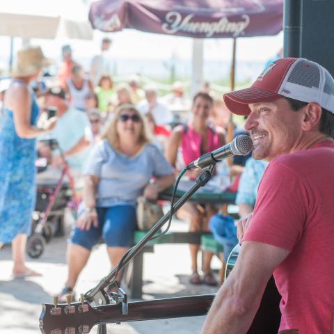 A performer smiles to a crowd at the Mucky Duck, a beachfront restaurant on Captiva Island. 